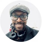 Black male with glasses, headphones and hat